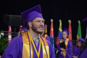 honor student walks proudly across the stage to receive his diploma