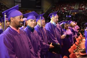 male students wearing purple caps and gowns