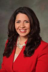 professional headshot of female in red suit jacket