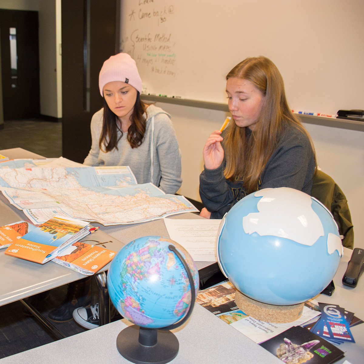 CCD Geology students looking at maps and globes