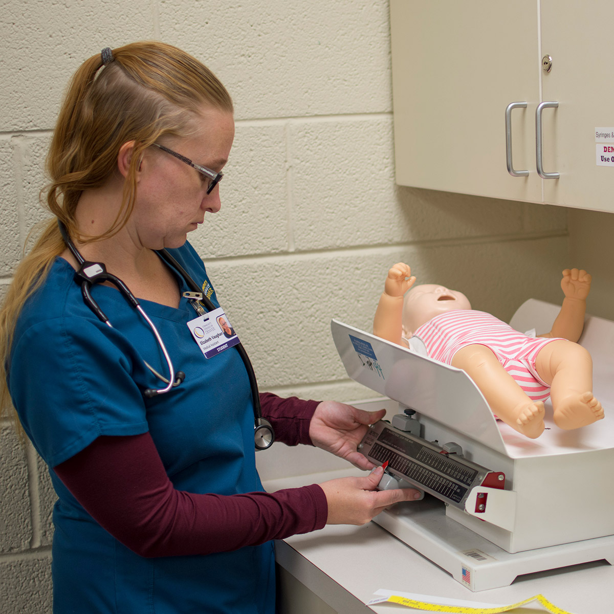 CCD Medical Assistant student weighing a baby dummy