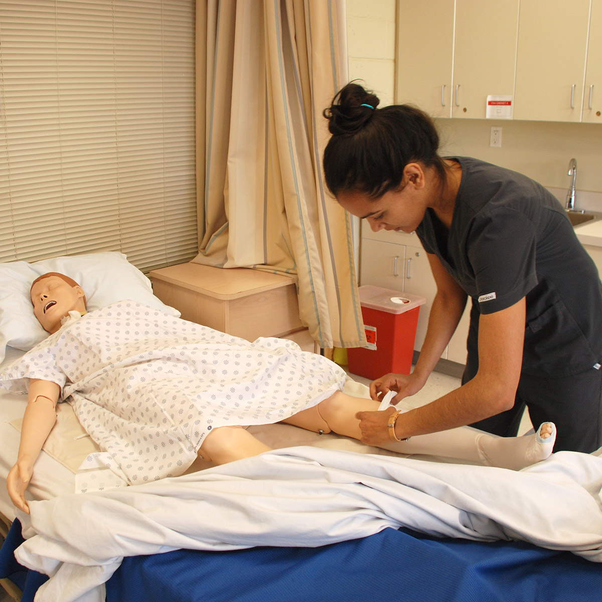 CCD Practical Nursing student bandaging a dummy's leg