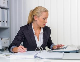 Female accountant using an adding machine