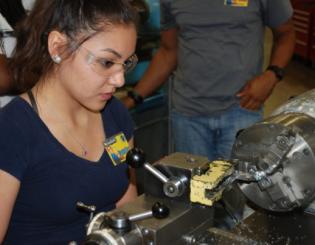 female works on machining equipment