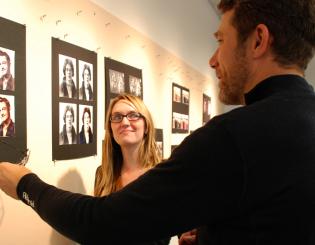 man and woman discuss the graphic image on the wall created by graphic designer