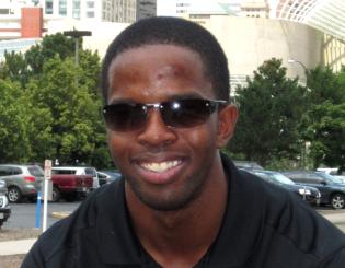 young man with sunglasses smiles at the camera