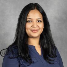 Woman with long black hair wearing dark blue top