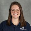 Woman with shoulder-length brown hair wearing wire-rimmed glasses and navy polo